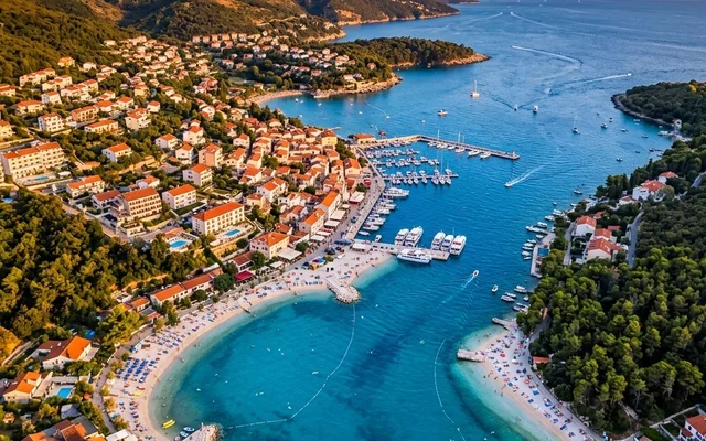 Rabac — bela šljunkovita plaža u zelenom zalivu, marina i hoteli na pošumljenim padinama, istočna Istra, Hrvatska