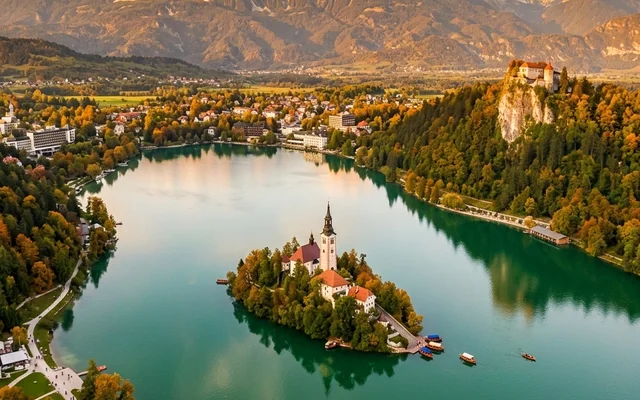 Bled — smaragdno jezero sa ostrvom i crkvom, Blejski grad na litici i Alpe u pozadini, severna Slovenija